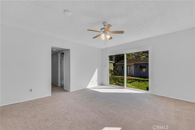 spare room featuring baseboards, carpet, a ceiling fan, and a textured ceiling