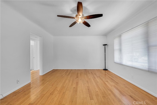 unfurnished room featuring a ceiling fan, light wood-style floors, and baseboards