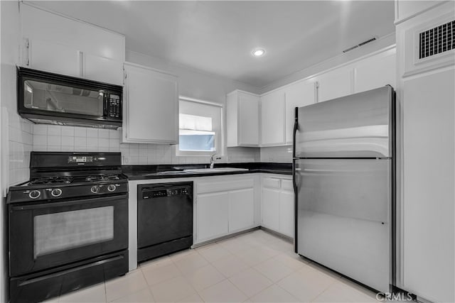 kitchen with dark countertops, visible vents, black appliances, and a sink