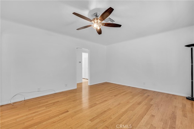 spare room with light wood finished floors, visible vents, baseboards, and ceiling fan