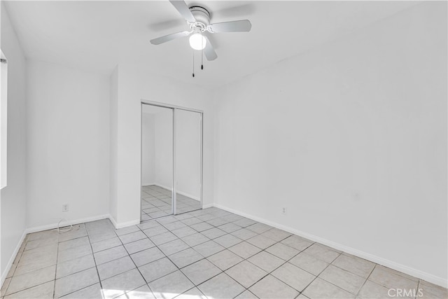 spare room with light tile patterned floors, baseboards, and a ceiling fan