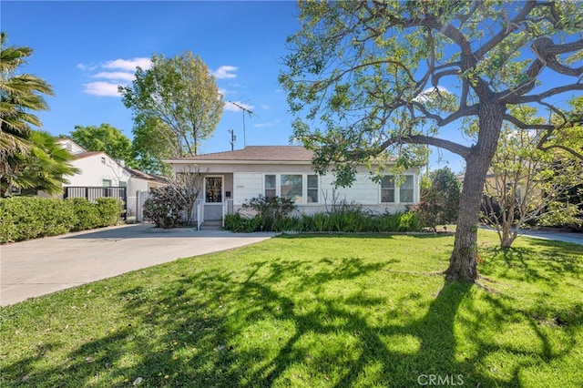 view of front of property with concrete driveway and a front yard