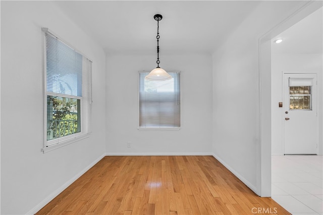 spare room with light wood-style floors and baseboards