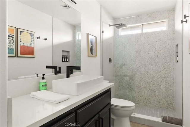 bathroom with visible vents, vanity, toilet, and a shower stall