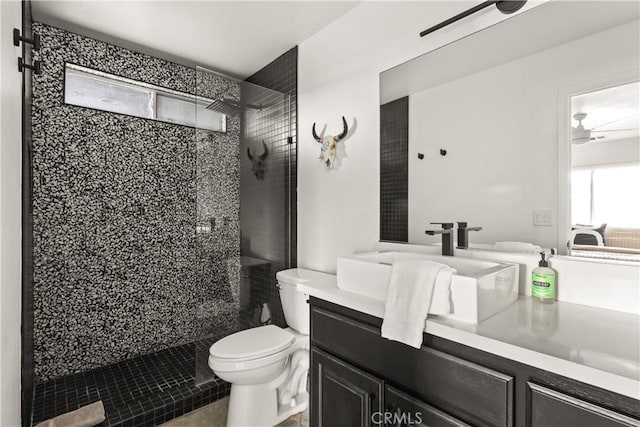 bathroom featuring vanity, toilet, a ceiling fan, and a stall shower