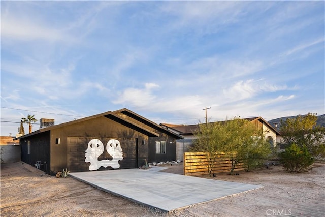 view of home's exterior featuring fence, driveway, and stucco siding