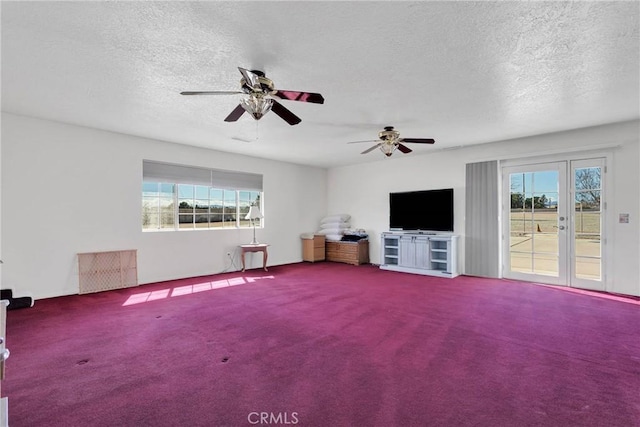 unfurnished living room featuring a textured ceiling, ceiling fan, and carpet floors