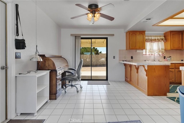 kitchen featuring tile countertops, visible vents, tasteful backsplash, and brown cabinetry