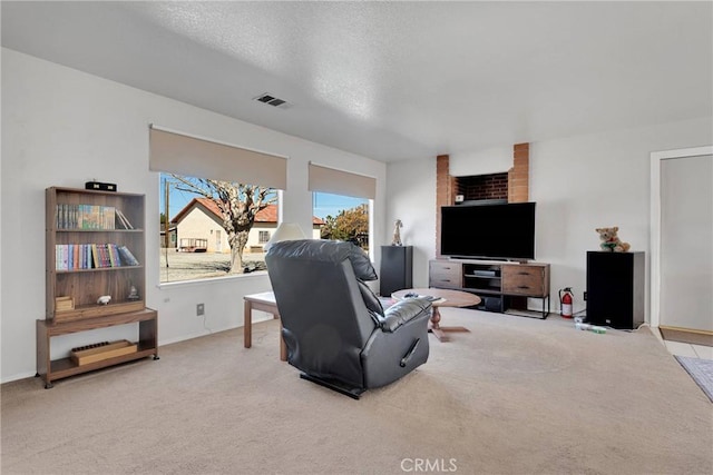 living area with visible vents, a textured ceiling, and carpet