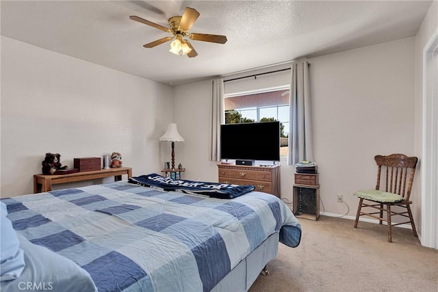 bedroom with light colored carpet, a textured ceiling, baseboards, and ceiling fan