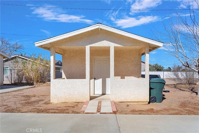 view of front facade featuring fence and stucco siding