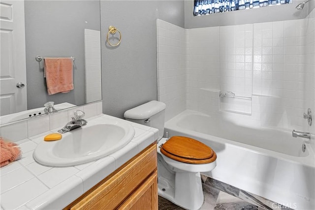 bathroom with vanity, toilet, bathing tub / shower combination, and a textured wall