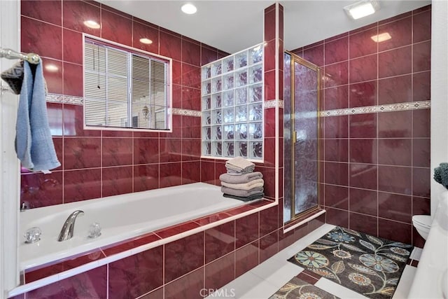 bathroom featuring a garden tub, a stall shower, and tile patterned flooring