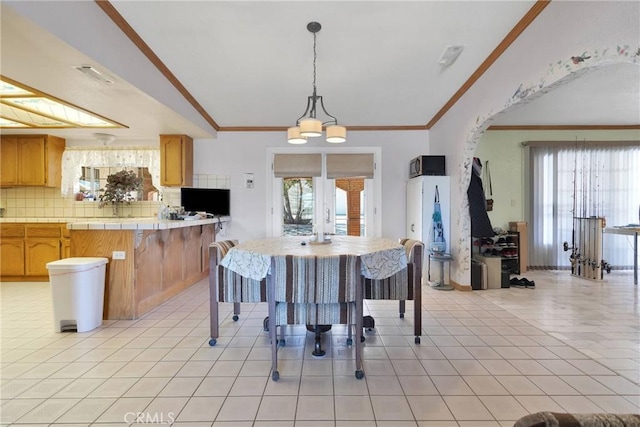 kitchen featuring backsplash, tile counters, light tile patterned flooring, and a wealth of natural light