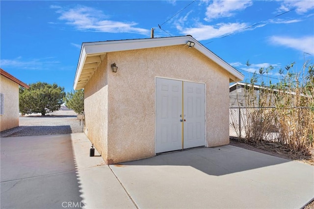 view of outdoor structure featuring an outbuilding and fence