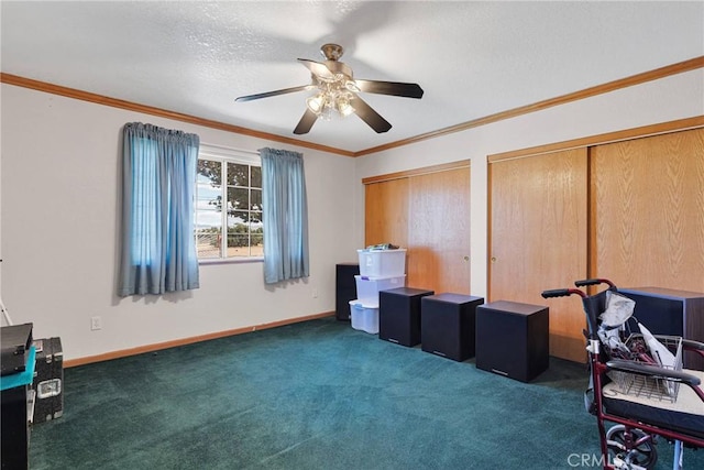 interior space with crown molding, ceiling fan, baseboards, multiple closets, and a textured ceiling