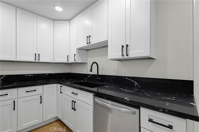 kitchen with white cabinets, dishwasher, dark stone counters, and a sink