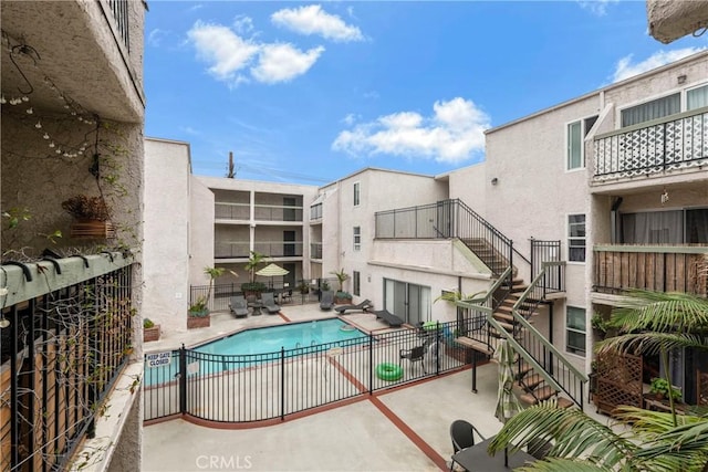 pool featuring a patio, stairway, and fence