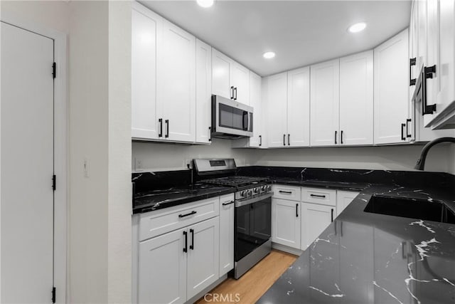 kitchen with white cabinetry and appliances with stainless steel finishes