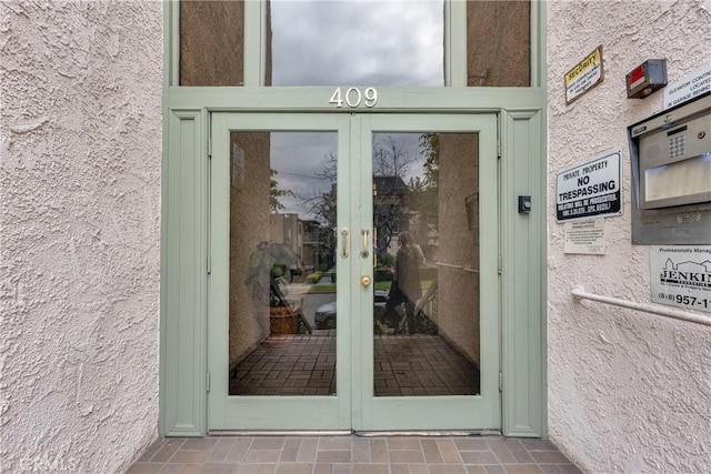 property entrance featuring french doors and stucco siding