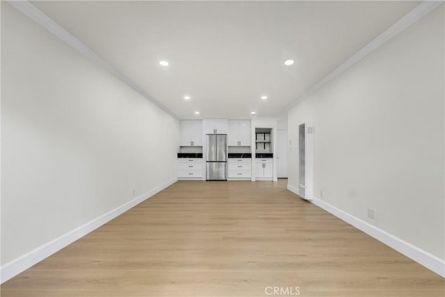 unfurnished living room with recessed lighting, light wood-style floors, baseboards, and ornamental molding