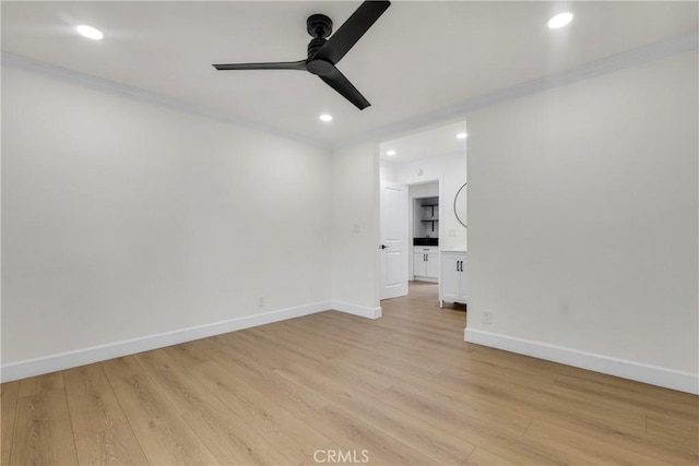 empty room featuring light wood-type flooring, recessed lighting, crown molding, baseboards, and ceiling fan