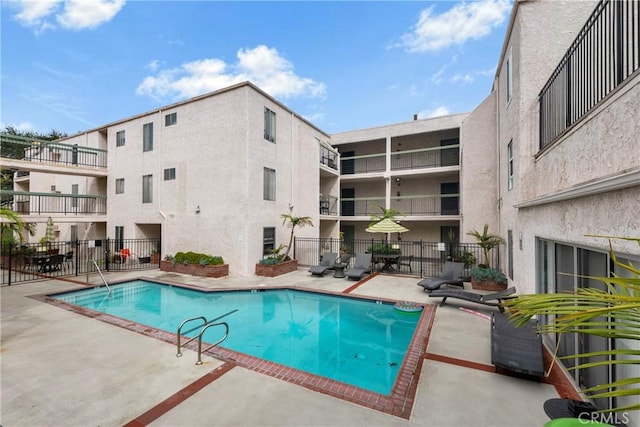 community pool featuring a patio area and fence