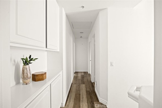 hall featuring dark wood-type flooring and baseboards