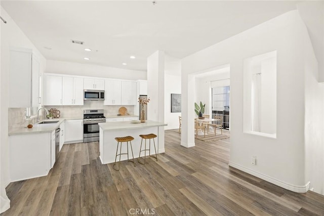 kitchen featuring a sink, tasteful backsplash, appliances with stainless steel finishes, and light countertops