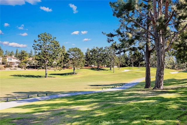 view of community featuring a lawn and view of golf course