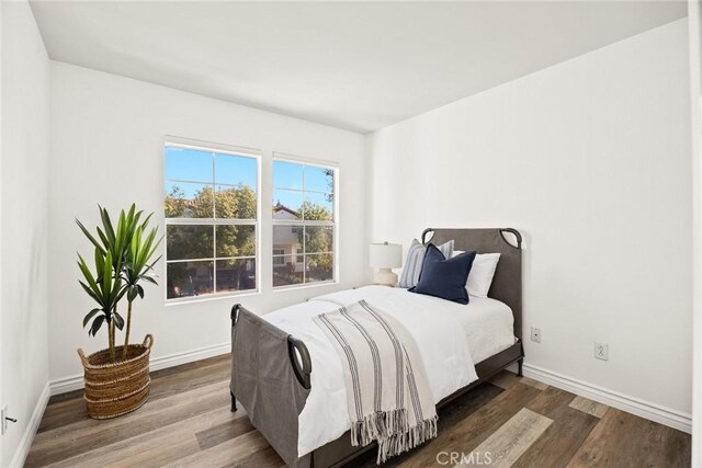 bedroom featuring baseboards and wood finished floors