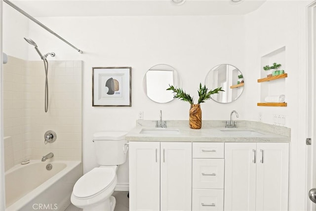 bathroom with double vanity, toilet, shower / tub combination, and a sink