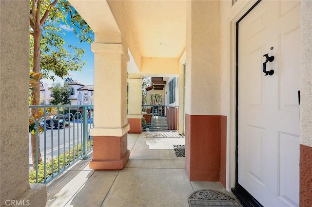 entrance to property featuring a balcony, a residential view, and stucco siding