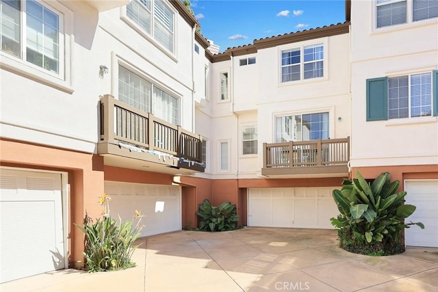 exterior space featuring stucco siding, a garage, and driveway