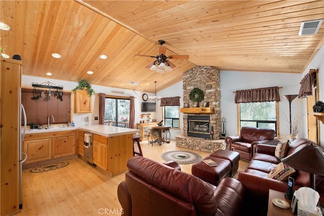 living area featuring visible vents, wood ceiling, lofted ceiling, a stone fireplace, and light wood-style floors