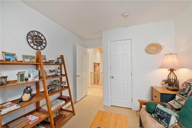 living area with baseboards and light colored carpet