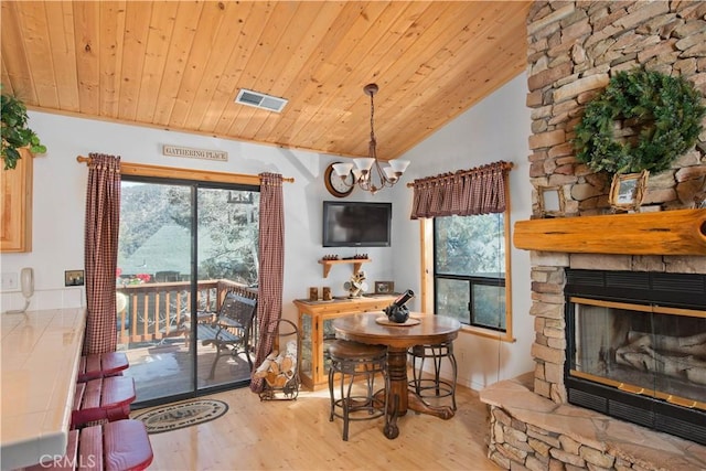 dining room with wood finished floors, plenty of natural light, and a fireplace