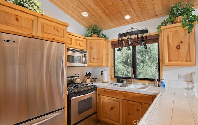 kitchen with lofted ceiling, recessed lighting, stainless steel appliances, tile counters, and wooden ceiling