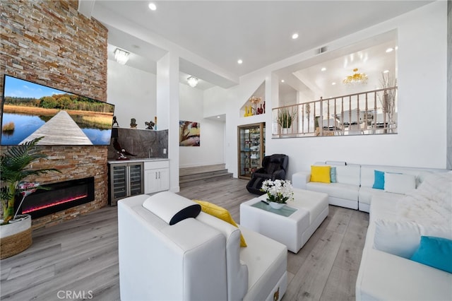 living room featuring recessed lighting, wood finished floors, beverage cooler, and a fireplace