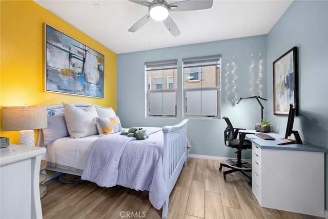 bedroom with light wood-style floors, baseboards, and ceiling fan