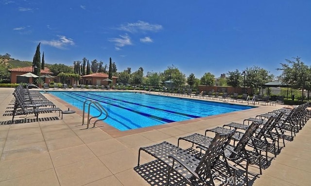 community pool featuring a patio and fence