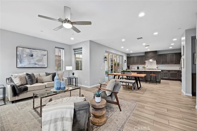 living room featuring light wood-style flooring, recessed lighting, baseboards, and ceiling fan