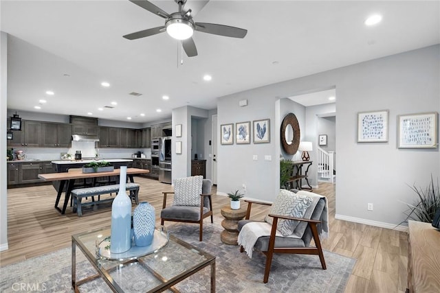 living area featuring recessed lighting, light wood-style floors, and baseboards