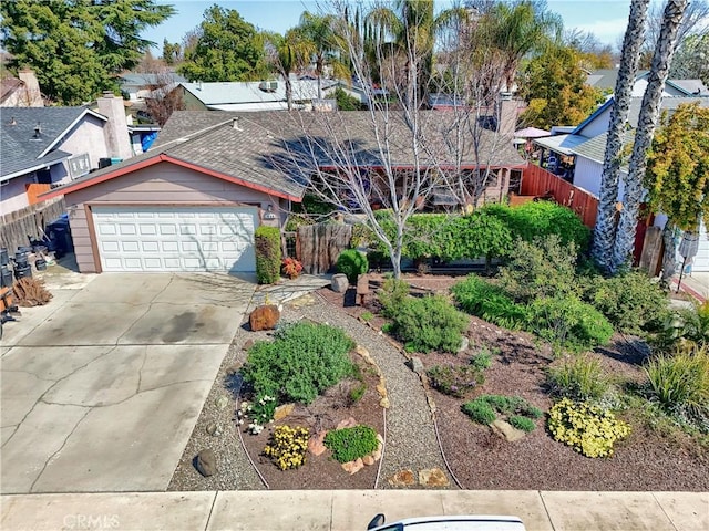 view of front of home featuring a residential view, an attached garage, concrete driveway, and fence