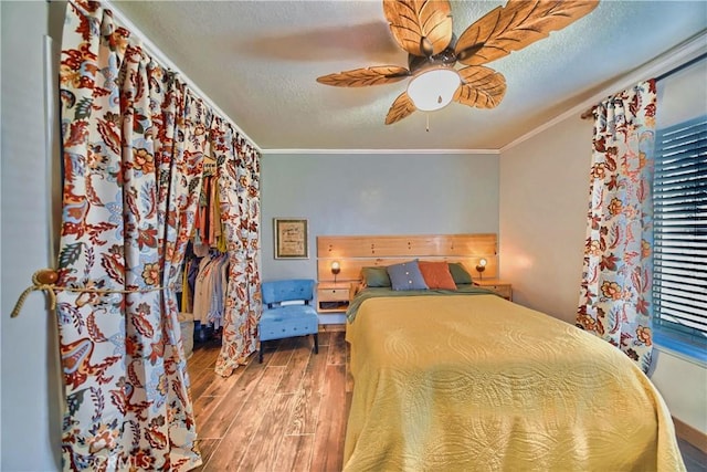 unfurnished bedroom featuring a ceiling fan, a textured ceiling, wood finished floors, and crown molding