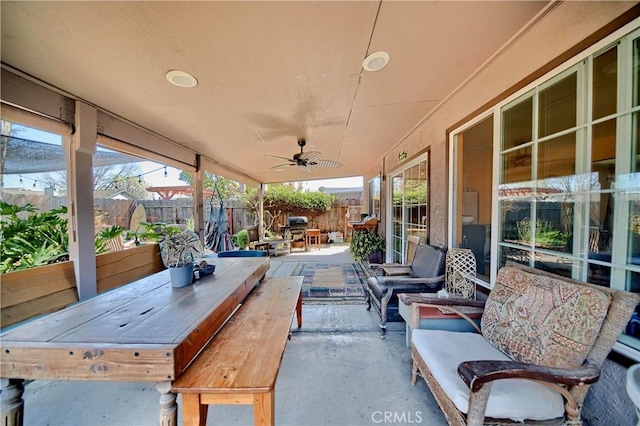 view of patio with area for grilling, outdoor dining area, a ceiling fan, and fence