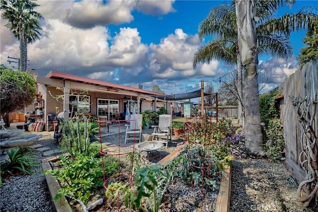 rear view of property with a patio area, fence, and a garden