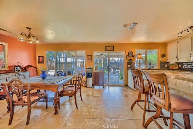 dining space with visible vents, a wealth of natural light, and a chandelier