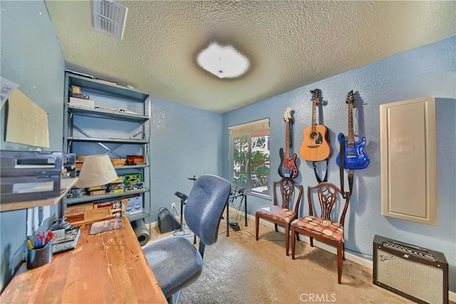 carpeted home office featuring visible vents, baseboards, a textured wall, heating unit, and a textured ceiling