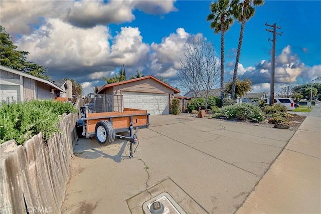 view of front of house featuring a detached garage, an outbuilding, and fence